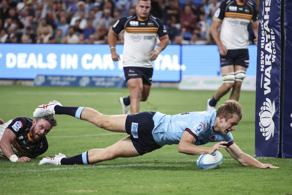 Max Jorgensen, right, from the New South Wales Waratahs scores a try during the Super Rugby Pacific Round 1 match against the ACT Brumbies at Allianz Stadium in Sydney, Australia Friday, Feb. 24, 2023. (David Gray/AAP Image via AP)