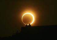 Two men sit on a bridge to watch an annular solar eclipse in Zhengzhou, Henan province, January 15, 2010. The longest, ring-like solar eclipse of the millennium started on Friday, with astronomers saying the Maldives was the best place to view the phenomenon that will not happen again for over 1,000 years. REUTERS/Donald Chan