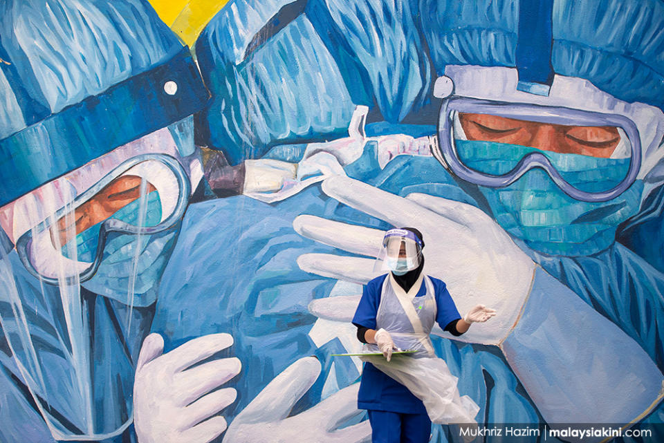 A doctor wearing personal protective equipment waits for patients at a drive-thru Covid-19 testing centre outside Clinic Ajwa in Shah Alam, Selangor on Dec 10, 2020.