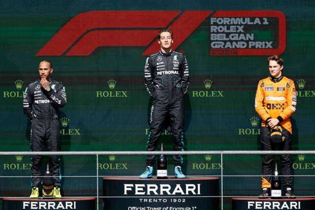 Race winner George Russell (centre) stands on the podium, with team-mate Lewis Hamilton to his right and Oscar Piastri to his left