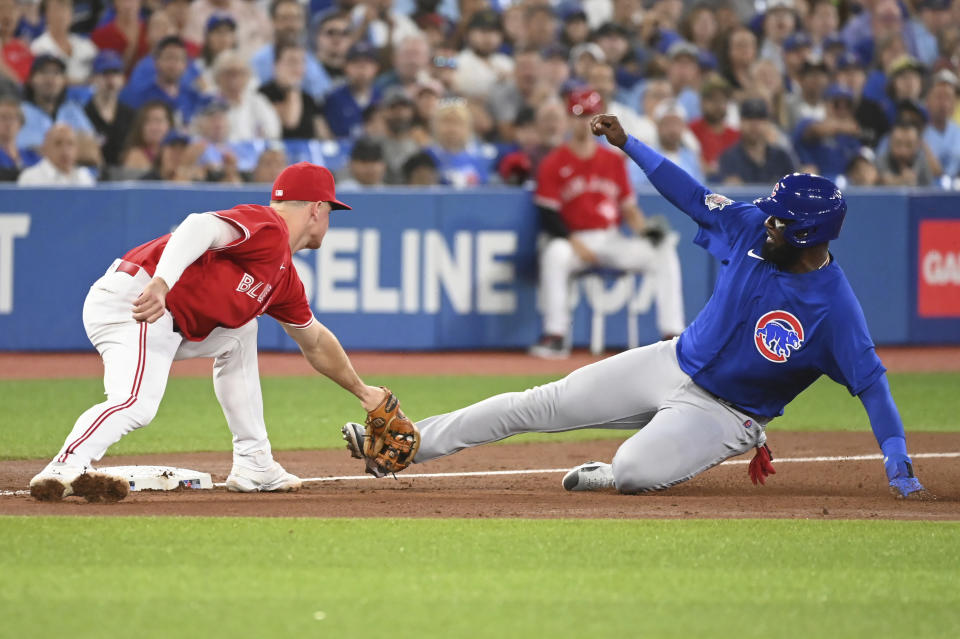 Toronto Blue Jays third baseman Matt Chapman, left, tags out Chicago Cubs designated hitter Franmil Reyes, right, in fourth-inning baseball game action in Toronto, Monday, Aug. 29, 2022. (Jon Blacker/The Canadian Press via AP)