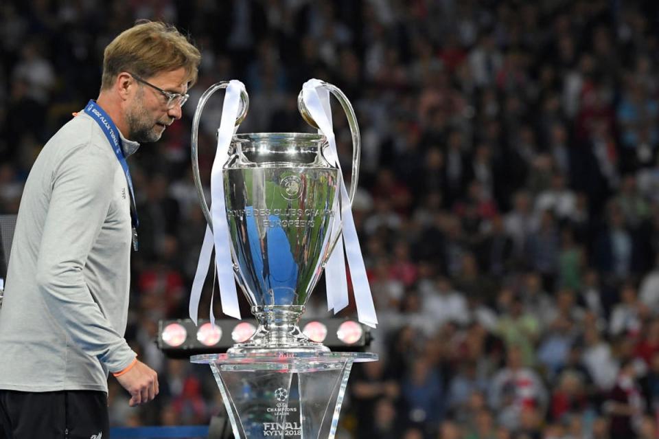 So close... a despondent Klopp passes the Champions League trophy after defeat in 2018  (AFP/Getty)