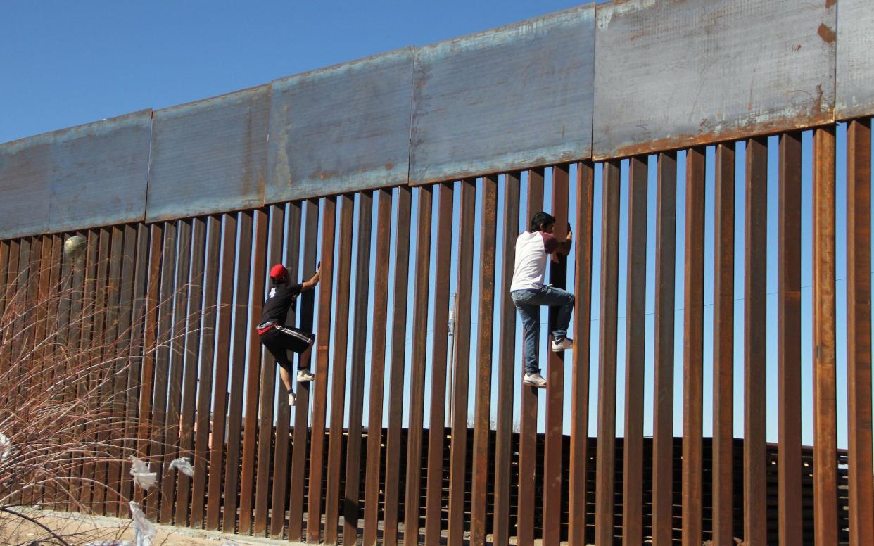 Boys play around, climbing the border division between Mexico and the US in Ciudad Juarez: AFP/Getty Images