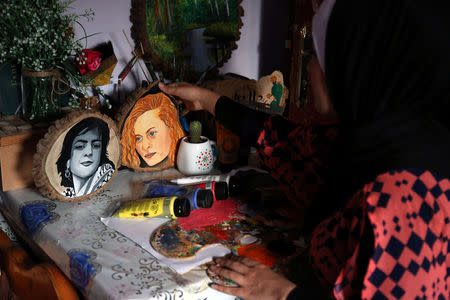 Palestinian artist Reham al-Emawi, who paints works in support of anti-Israel protests, works at her house in Rafah, in the southern Gaza Strip April 14, 2018. REUTERS/Samar Abo Elouf