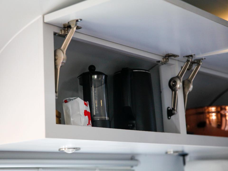 goods needed to make coffee inside of a shelf