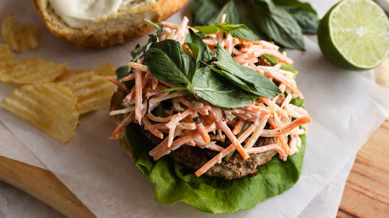 Close up on open turkey burger with carrot slaw and Thai basil