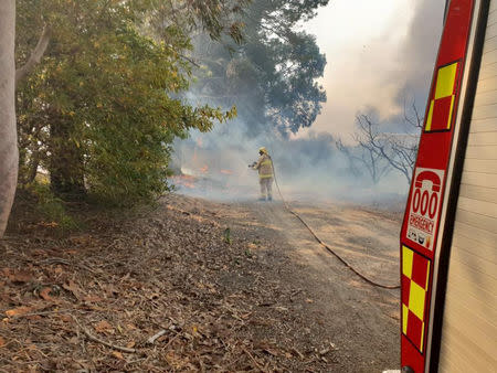 A firefighter battles a bushfire in New South Wales, Australia, August 15, 2018, in this picture obtained from social media. Fire and Rescue NSW/via REUTERS