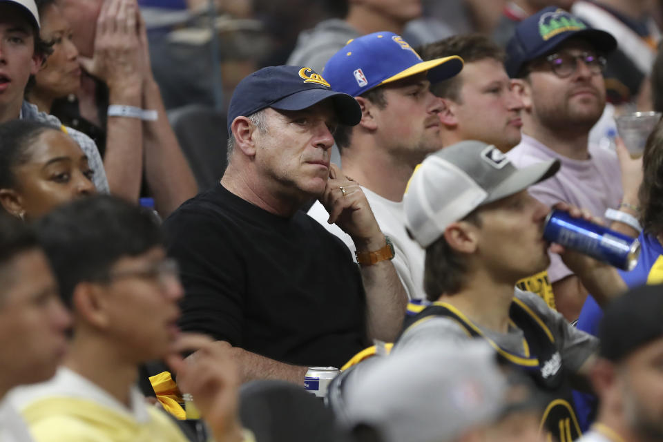 FILE - Oakland Athletics owner John Fisher, center, watches during Game 2 of basketball's NBA Finals between the Golden State Warriors and the Boston Celtics in San Francisco, Sunday, June 5, 2022. Athletics reliever Trevor May ripped Oakland owner John Fisher and implored him to sell the franchise while announcing his retirement Monday, Oct. 17, 2023, in an empassioned video message. (AP Photo/Jed Jacobsohn, File)