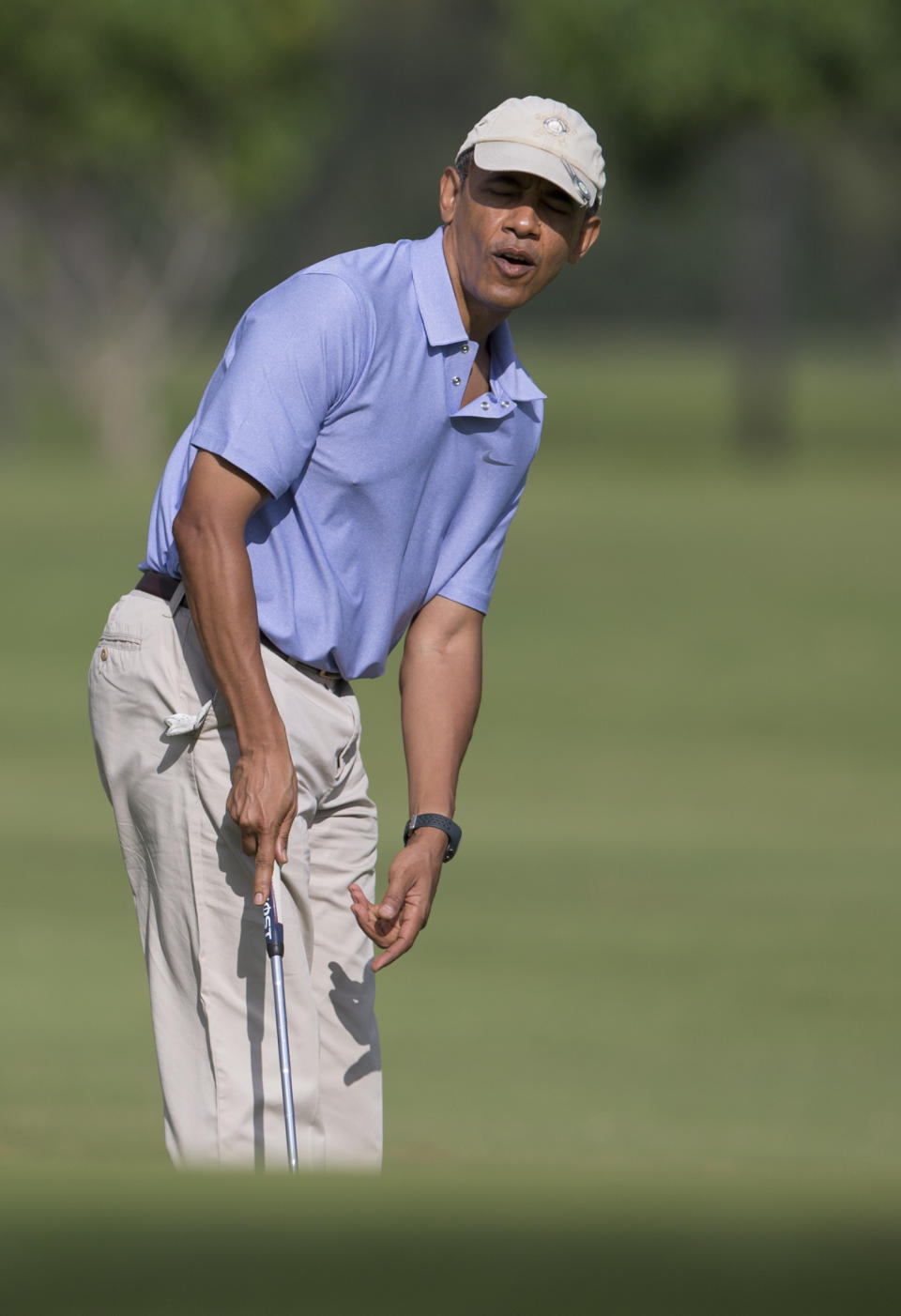 President Barack Obama reacts as he watches his putt on the second green at Kaneohe Klipper Golf Course on Marine Corps Base Hawaii in Kaneohe Bay, Hawaii, Thursday, Jan. 2, 2014. The first family is in Hawaii for their annual holiday vacation. (AP Photo/Carolyn Kaster)