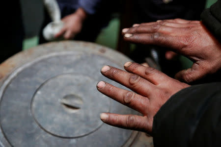 Setevdorj Myagmartsogt holds his hands above his new coal burning stove while talking to reporters in Ulaanbaatar, Mongolia January 29, 2017. Setevdorj Myagmartsogt lives with his wife, four children and two relatives in his cramped ger home above a coal depot not far from the city centre. The government offers free electricity to homes without access to city's central heating grid, but electric heating units are too expensive to families like MyagmartsogtÕs. The family doesnÕt have access to their own electricity line and borrows it from a neighbour. REUTERS/B. Rentsendorj