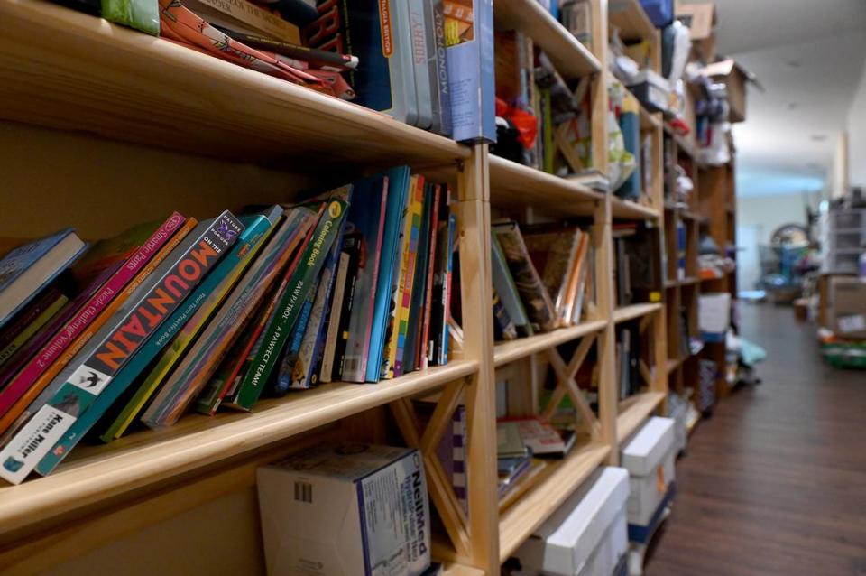 A hallway in Mindy and Roy’s home is lined with bookshelves and filled with books and toys for all ages.