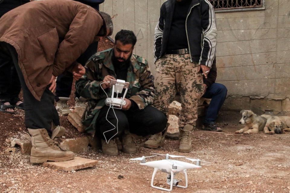 A man sitting and looking at a drone.