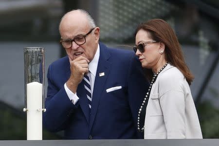 Former New York City Mayor Rudy Giuliani and his wife, Judith Giuliani, look at a candle on the South Pool at the World Trade Center in New York, September 25, 2015. REUTERs/Julio Cortez/AP/POOL