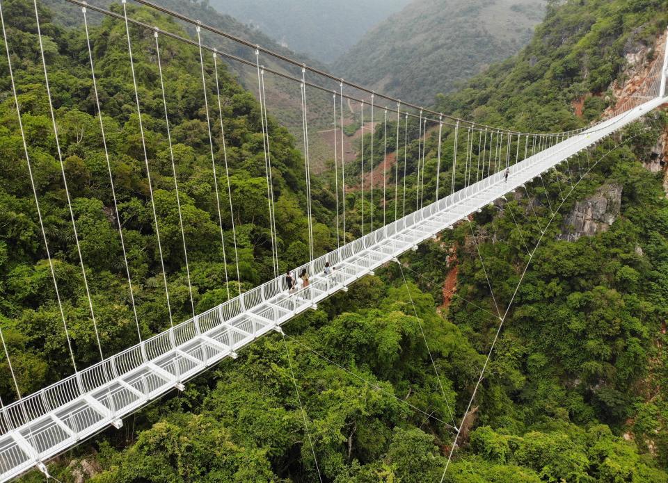 people walk across the Bach Long glass bridge in the Moc Chau district in Vietnam's Son La province