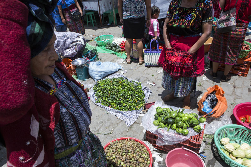 Women sell vegetables in the market at the central park of San Martin Jilotepeque, Guatemala, Sunday, August 4, 2019. San Martin Jilotepeque, like other towns in Guatemala, depends to a large extent on remittances, the money sent home by migrants living in the United States. (AP Photo/ Oliver de Ros)