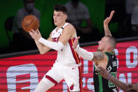 Miami Heat's Tyler Herro, left, passes the ball away from Boston Celtics' Daniel Theis (27) during the second half of an NBA conference final playoff basketball game Friday, Sept. 25, 2020, in Lake Buena Vista, Fla. (AP Photo/Mark J. Terrill)