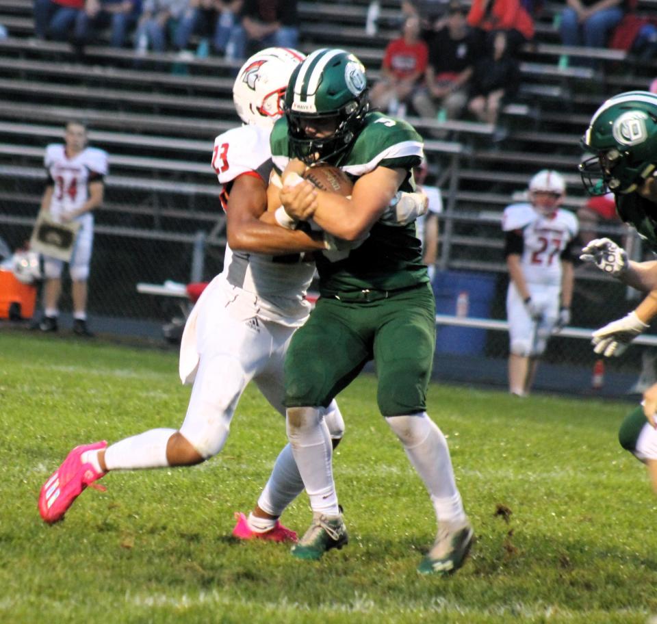 Dover's Ryder Aubin attempts to break the tackle of Sanford's Makai Bougie during action Friday night at Dunaway Field.