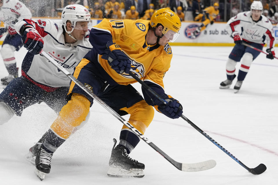 Nashville Predators center Gustav Nyquist, right, moves the puck past Washington Capitals defenseman Martin Fehervary, left, during the second period of an NHL hockey game Saturday, Dec. 16, 2023, in Nashville, Tenn. (AP Photo/George Walker IV)