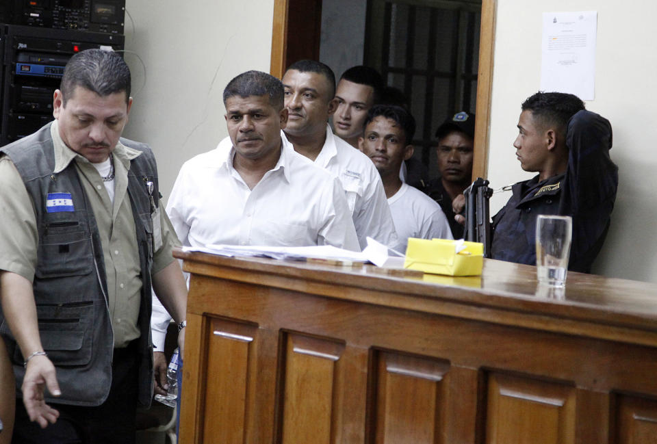 The men accused in the killing prize-winning Honduran indigenous and environmental rights activist Berta Caceres enter the court room in Tegucigalpa, Honduras, Monday, Sept. 17, 2018. Honduras' supreme court has indefinitely suspended the start of the trial of eight men accused in the 2016 killing of Caceres, citing five related filings pending at the criminal appeals court that have to be resolved. (AP Photo/Fernando Antonio)