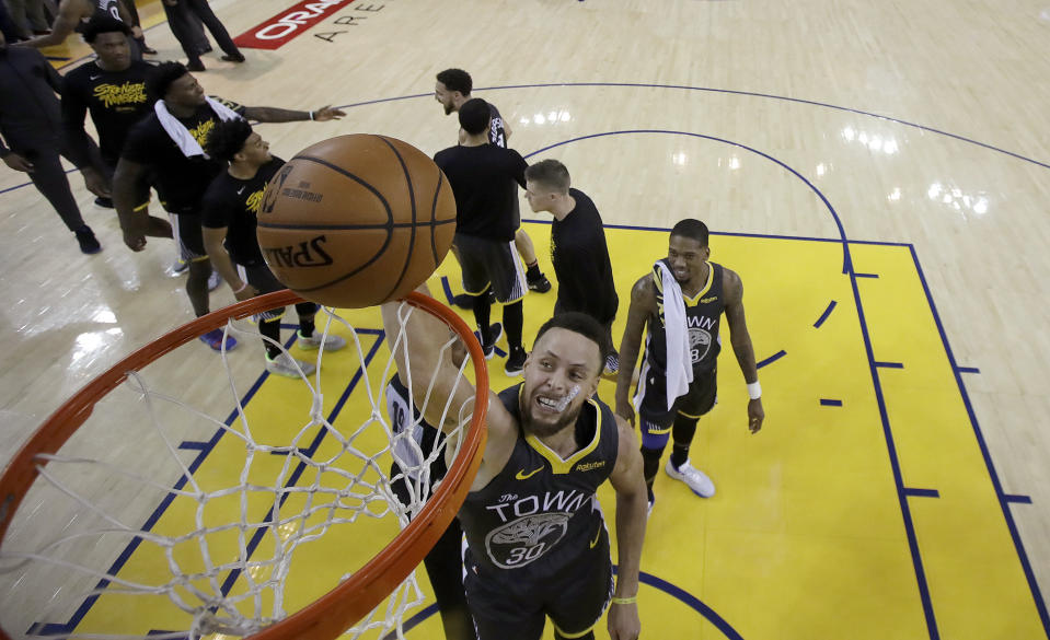 Golden State Warriors guard Stephen Curry dunks as teammates celebrate after defeating the Portland Trail Blazers 114-111 in Game 2 of the NBA basketball playoffs Western Conference finals in Oakland, Calif., Thursday, May 16, 2019. (AP Photo/Jeff Chiu, Pool)