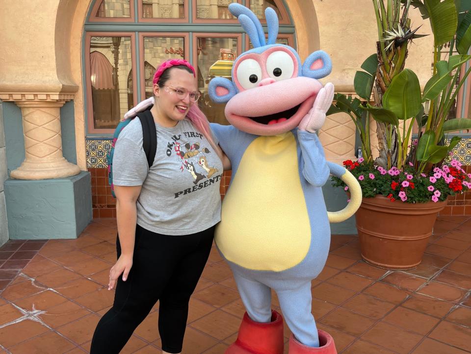 casey posing with boots from dora the explorer at universal