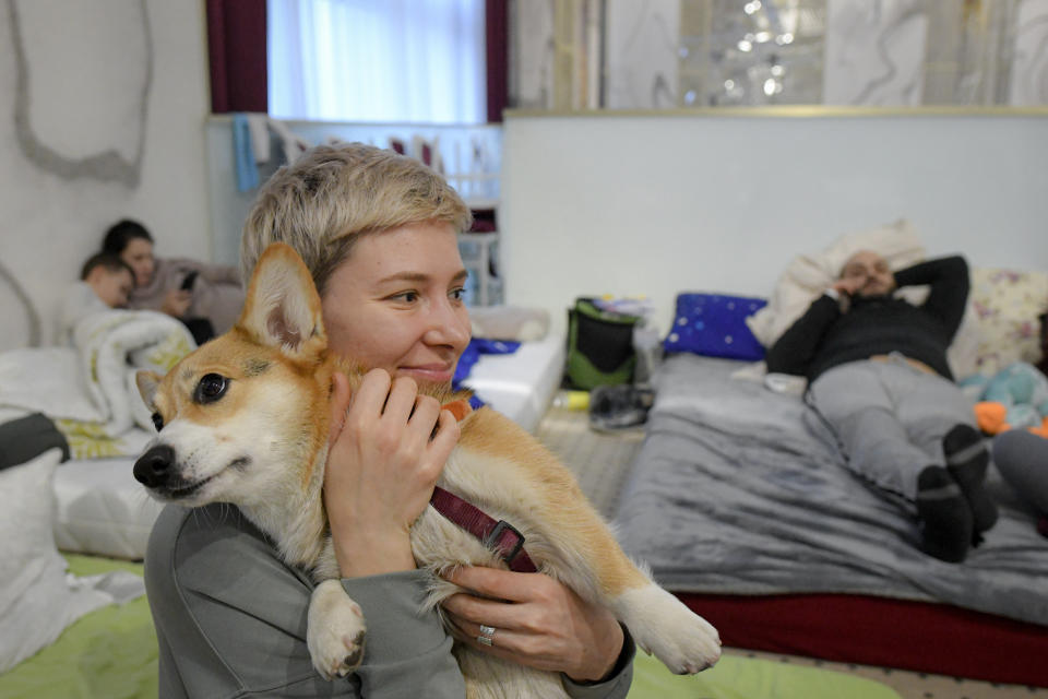 Olga Okhrimenko holds her dog, Knolly, in a ballroom converted into a refugee shelter.