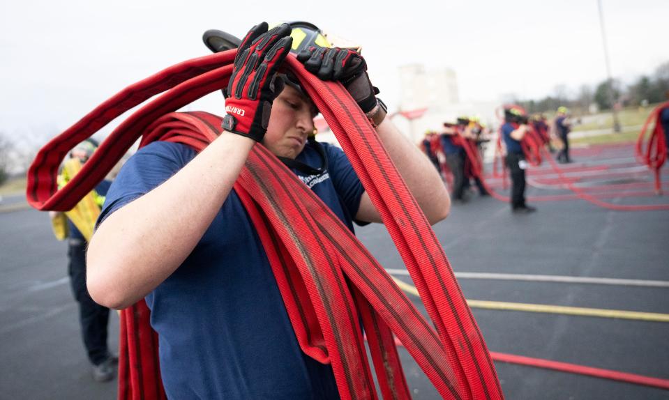 Jakob Baxter, who hopes to become a volunteer firefighter, gathers a firehose after training at the Division of State Fire Marshal's Ohio Fire Academy.