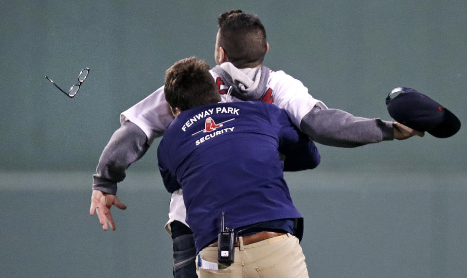 A Fenway Park security worker took down a fan who ran onto the field during the fifth inning of a baseball game Wednesday night. (AP)