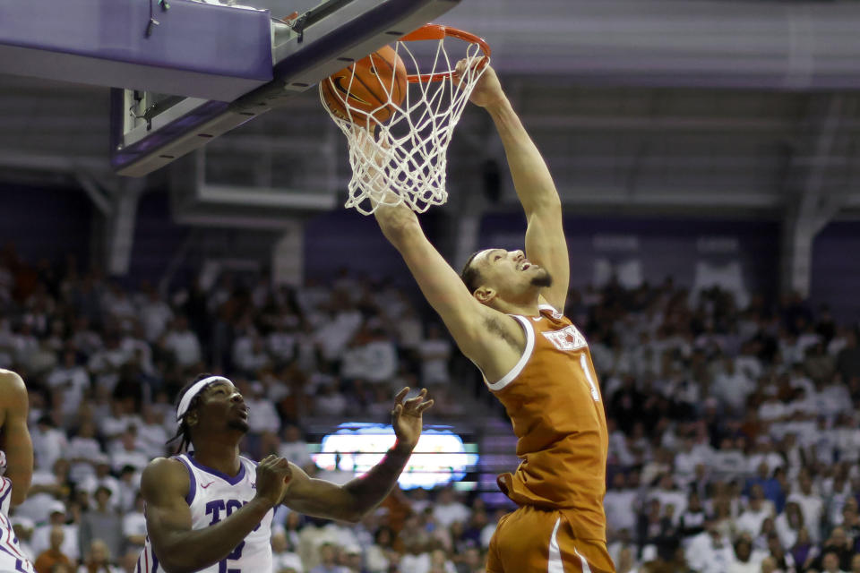 Texas forward Dylan Disu (1) dunks in front of TCU forward Emanuel Miller (2) during the second half of an NCAA college basketball game in Fort Worth, Texas, Saturday, Feb. 3, 2024. (AP Photo/Michael Ainsworth)