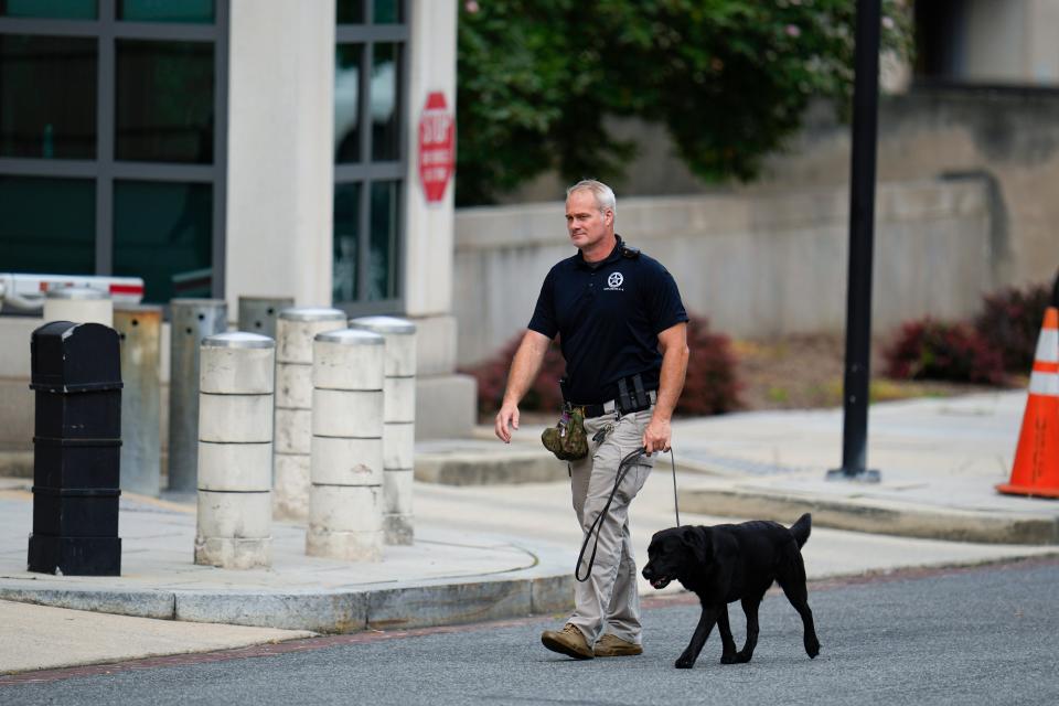 U.S. Marshals Service K-9 officer patrols the area outside the E. Barrett Prettyman U.S. Federal Courthouse, Thursday, Aug. 3, 2023, in Washington. Former President Donald Trump is due in court on Thursday, the first step in a legal process that will play out in a courthouse between the White House he once controlled and the Capitol his supporters once stormed. (AP Photo/Julio Cortez) ORG XMIT: DCJC401