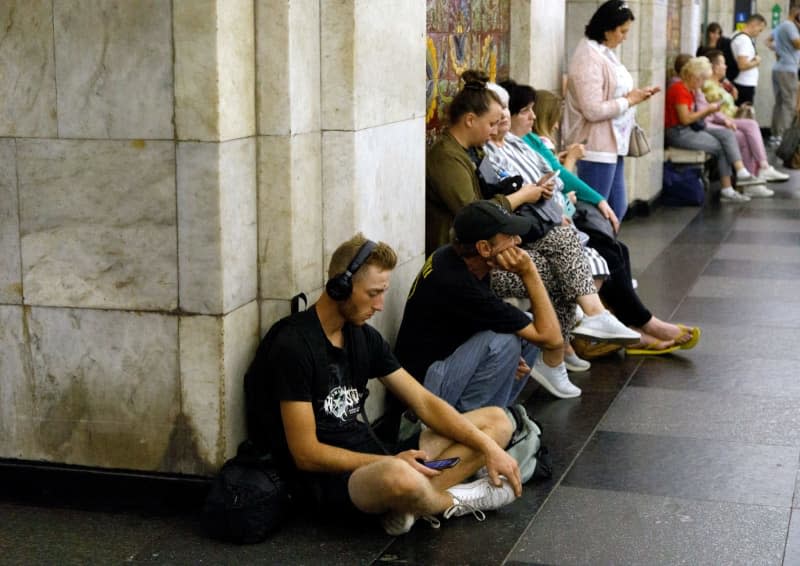 People wait for an air raid siren at the Khreshchatyk metro station during a massive Russian drone and missile attack. -/ukrin/dpa