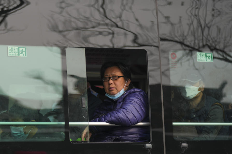 A woman looks out from a window of a city bus in Beijing, China, Wednesday, April 3, 2024. (AP Photo/Tatan Syuflana)