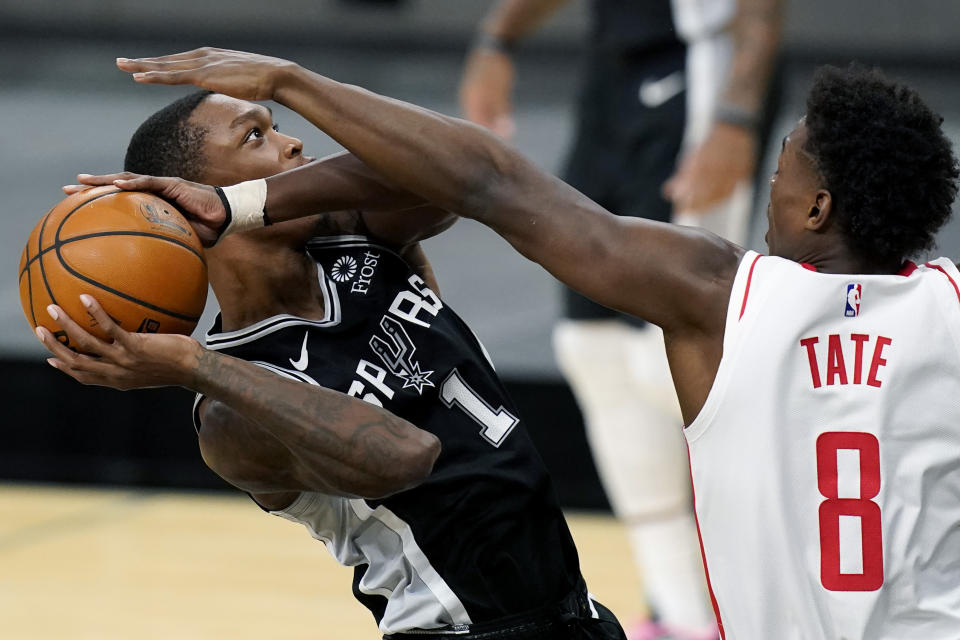 San Antonio Spurs guard Lonnie Walker IV (1) drives to the basket against Houston Rockets forward Jae'Sean Tate (8) during the first half of an NBA basketball game in San Antonio, Thursday, Jan. 14, 2021. (AP Photo/Eric Gay)