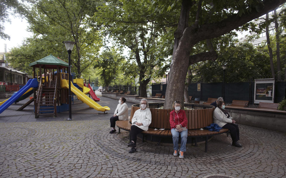 People sit in a public garden as only senior Turks over 65 have been allowed to go out for six hours during a curfew declared by the government in an attempt to control the spread of coronavirus, in Ankara, Turkey, Sunday, May 31, 2020. The country has opted to impose short weekend and holiday curfews, instead of full lockdowns, fearing possible negative effects on the already troubled economy.(AP Photo/Burhan Ozbilici)