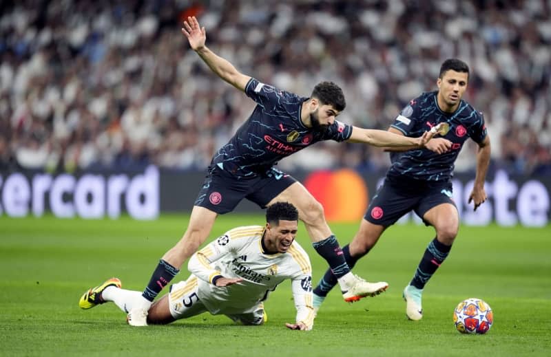 Real Madrid's Jude Bellingham (bottom) and Manchester City's Josko Gvardiol (L) battle for the ball during the UEFA Champions League quarter-final, first leg soccer match between Real Madrid and Manchester City at the Santiago Bernabeu Stadium. Nick Potts/PA Wire/dpa