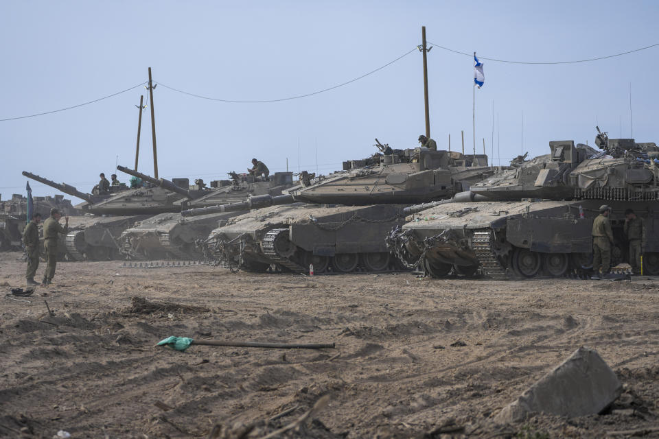 Israeli soldiers work on their tanks in a staging area near the border with the Gaza Strip, in southern Israel, Monday, April 8, 2024. (AP Photo/Tsafrir Abayov)