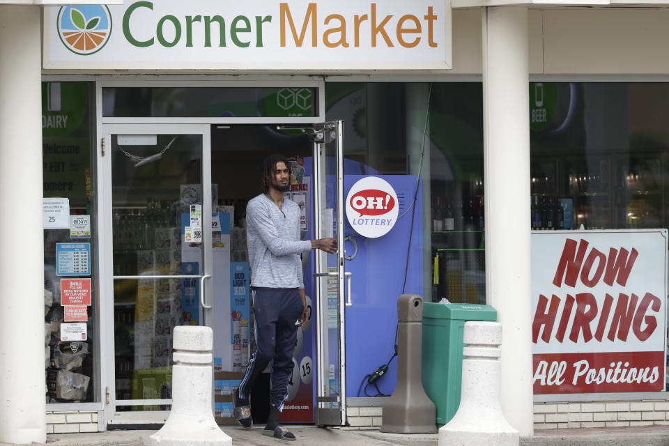 A sign "Now Hiring" rests in a window as a man walks out of the Corner Market, Thursday, May 28, 2020, in Lyndhurst, Ohio. The state says about 1.3 million Ohioans have filed unemployment claims in the past 10 weeks as Ohio's stay-at-home order depressed the economy and led to widespread layoffs. The Ohio Department of Job and Family Services says about 42,000 people filed claims for the week ending May 23. (AP Photo/Tony Dejak)