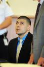 Former NFL New England Patriots football player Aaron Hernandez looks up at his defense attorney, Charles Rankin during a hearing at the Bristol County Superior Court House in Fall River, Massachusetts, June 16, 2014. Attorneys for former NFL star Aaron Hernandez on Monday called on a judge to throw out charges that the ex-tight end murdered a semiprofessional football player in June 2013, one of three homicides Hernandez is charged with. REUTERS/Faith Ninivaggi/POOL (UNITED STATES - Tags: CRIME LAW SPORT)