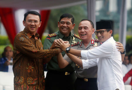 (L-R) Candidates running in Jakarta governor election Basuki Tjahaja Purnama, Jakarta military chief Jaswandi, Jakarta Police chief Mochammad Iriawan, and a candidate for deputy governor Sandiaga Uno, hold hand during Peace Declaration ceremony for Wednesday election in Jakarta, Indonesia, April 17, 2017. REUTERS/Beawiharta