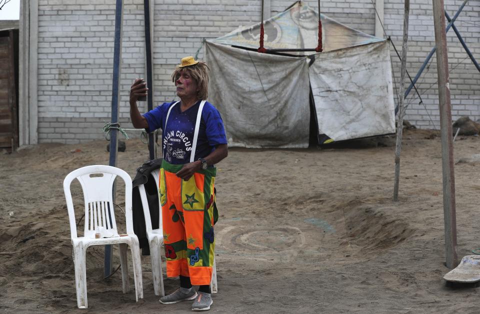 El payaso de circo Santos Chiroque, cuyo nombre artístico es "Piojito", se mira en un espejo mientras muestra su disfraz frente a su casa en las afueras de Lima, Perú, el lunes 10 de agosto de 2020. (AP Foto/Martín Mejía)