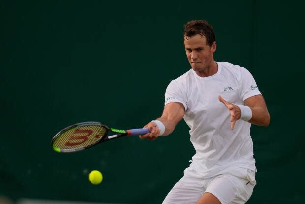 Canada's Vasek Pospisil plays a return to Frances Tiafoe of the U.S. during the men's singles second round match on the Wimbledon Tennis Championships in London in June. (Kirsty Wigglesworth/The Associated Press - image credit)