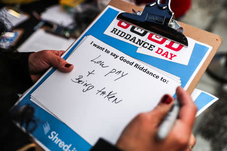 A person writes down a bad memory during the National Good Riddance day ceremonial shredding of bad memories of 2018 in Times Square in the Manhattan borough of New York, U.S., December 28, 2018. REUTERS/Jeenah Moon