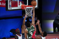 Milwaukee Bucks' Giannis Antetokounmpo (34) tips in a rebound against the Washington Wizards during the first half of an NBA basketball game, Tuesday, Aug. 11, 2020, in Lake Buena Vista, Fla. (AP Photo/Ashley Landis, Pool)