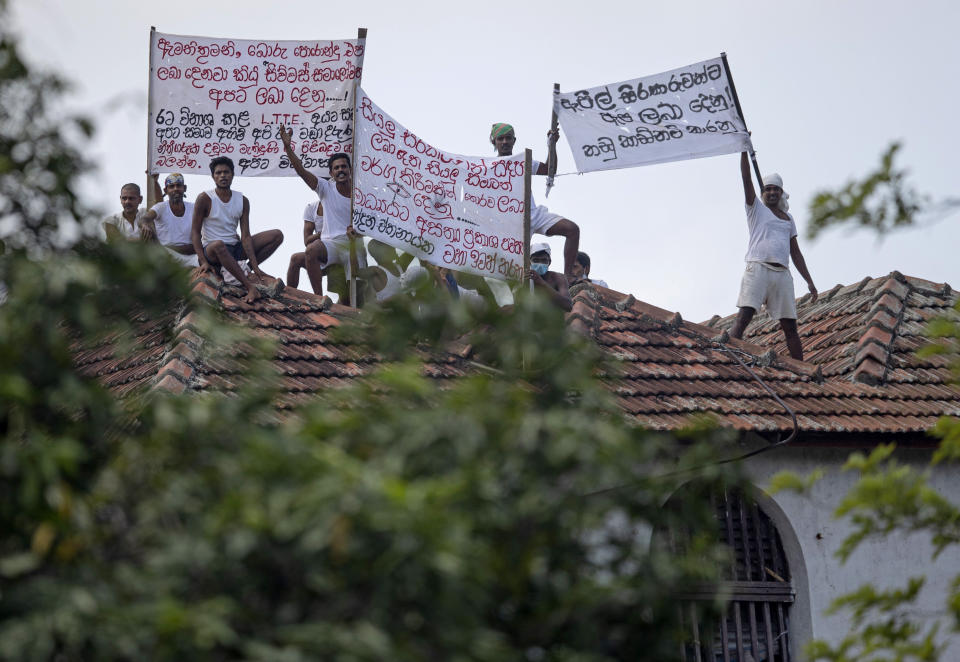 Death-row inmates of Sri Lanka's Welikada prison protest holding banners from the roof of the prison in Colombo, Sri Lanka, Friday, June 25, 2021. About 150 death-row inmates in Sri Lanka began a hunger strike to demand their sentences be commuted, prison officials said, after the nation's president pardoned a former lawmaker who had been condemned for an election-related killing. Banners read "Treat all inmates equally," "Grant bail on appeal applications," "Minister! Stop bogus promises," "Grant pardon to us like you did to terrorists and notorious politicians." (AP Photo/Eranga Jayawardena)