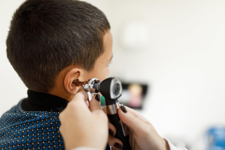 A doctor examining a kid's ear