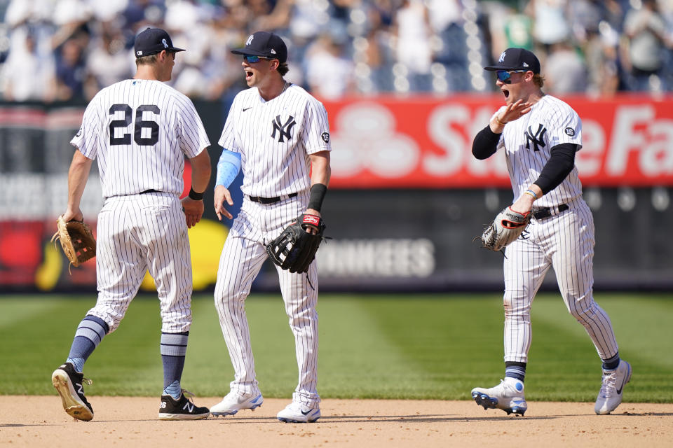 New York Yankees DJ LeMahieu, left, Tyler Wade, center, and Clint Frazier, right, celebrate after the Yankees completed a triple play to defeat the Oakland Athletics in the top of the ninth inning of a baseball game, Sunday, June 20, 2021, at Yankee Stadium in New York. (AP Photo/Kathy Willens)