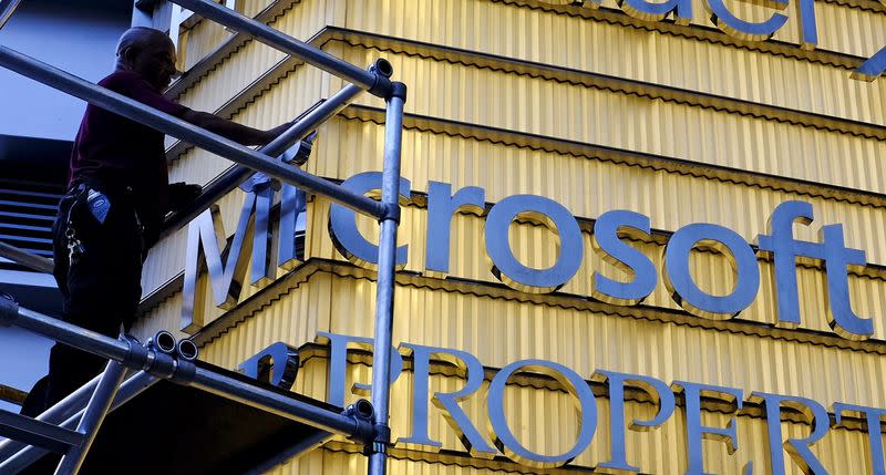 A worker cleans the letters of a Microsoft sign outside a corporate office in New York City, in this July 29, 2015 file photo. REUTERS/Rickey Rogers/Files