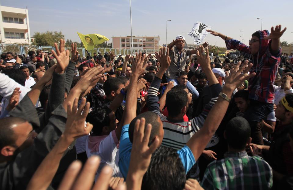 Supporters of the Muslim Brotherhood and ousted Egyptian President Mohamed Mursi shout slogans against the military and interior ministry, while gesturing with four fingers, during a protest outside the police academy, where Mursi's trial took place, on the outskirts of Cairo, November 4, 2013. Mursi struck a defiant tone on the first day of his trial on Monday, chanting 'Down with military rule', and calling himself the country's only 'legitimate' president. Mursi, an Islamist who was toppled by the army in July after mass protests against him, appeared angry and interrupted the session repeatedly, prompting a judge to adjourn the case. The "Rabaa" or "four" gesture is in reference to the police clearing of Rabaa al-Adawiya protest camp on August 14. REUTERS/Amr Abdallah Dalsh (EGYPT - Tags: POLITICS CIVIL UNREST)