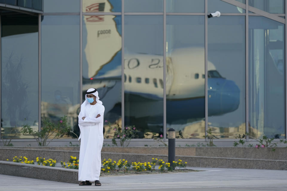 A man stands on a tarmac as Secretary of State Mike Pompeo's plane is reflected in windows at Al Bateen Executive Airport in Abu Dhabi, United Arab Emirates, Friday, Nov. 20, 2020. Pompeo is visiting the United Arab Emirates as part of a seven-nation trip to Europe and the Middle East. (AP Photo/Patrick Semansky, Pool)