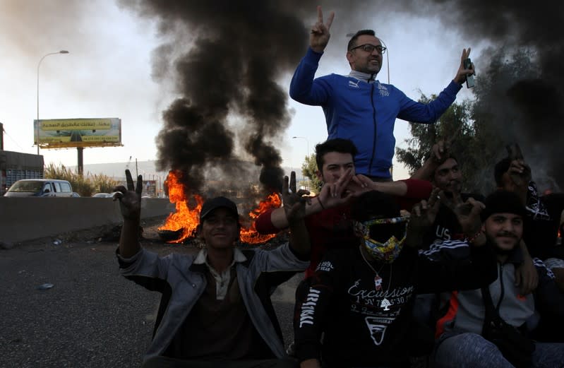 Demonstrators gesture to the camera during ongoing anti-government protests in Tripoli